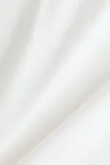 Remera de punto suave de algodón, de color blanco, con cuello redondo ribeteado y acanalado, corte holgado, hombros caídos y mangas cortas con doblez cosido.