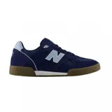 Championes urbanos New Balance modelo 600, color azul marino con detalles en celeste claro y suela de goma color caramelo. Presentan el logo N característico en los laterales y una combinación de materiales en gamuza y malla.