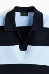 Remera polo de manga corta y corte holgado, confeccionada en punto de mezcla de viscosa. Presenta un diseño de rayas horizontales en color celeste y negro, con cuello acanalado y abertura frontal en V.
