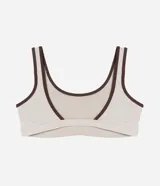 Top deportivo de microfibra con escote redondo delantero y escote en V en la espalda. Presenta un diseño bicolor con cuerpo en color crema y ribetes en color marrón oscuro, breteles anchos y copas desmontables.