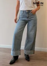 Pantalón de jean wide leg, tiro medio-alto, color celeste con lavado vintage, corte amplio y dobladillo ancho fijo en los tobillos.