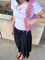 Remera blanca tipo baby tee de manga corta, con estampa roja pequeña al frente de unos zapatos Mary Jane.