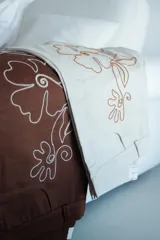 Pantalón slouchy color beige de gabardina de algodón con bordado floral marrón.