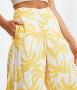 Pantalón pantalona de lino con estampado de cocoteros, cintura alta y cierre lateral invisible.