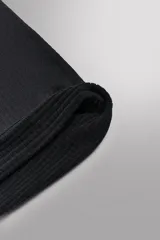 Cubre cuello técnico de color negro, confeccionado en tejido elástico Polartec con interior de estructura waffle. Presenta el logo de la marca estampado en un lateral.
