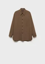 Camisa oversize de corte recto con diseño de raya diplomática, cuello camisero, cierre frontal de botones y bolsillo de parche en el pecho.