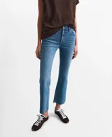 Jeans de denim celestes de tiro medio, con corte recto y terminación deshilachada en los tobillos.
