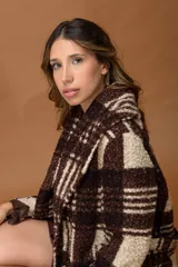 Tapado de corte recto confeccionado en tejido tipo corderito con estampado de cuadros en tonos beige y marrón chocolate. Presenta cuello solapa amplio, mangas largas y cinturón del mismo tejido para ajustar a la cintura.
