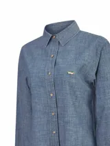 Blusa de manga larga Moroco de RKF, confeccionada en 100% algodón denim chambray color azul. Presenta cuello camisero, cierre frontal con botones de madera y un bordado del característico pato de la marca en el pecho.