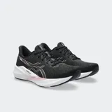 Championes de running Asics modelo Versablast 4, color negro con detalles en rosado y entresuela blanca con tecnología AmpliFoam+. Diseño ligero y reactivo para entrenamiento versátil.