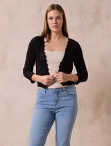 Cardigan tejido en hilado fino, color negro, marca Cable & Gauge. Abertura central con broche interno y terminación ondulada.