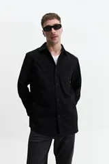 Sobrecamisa verde militar de twill de algodón, con cuello clásico, cierre frontal con botones a tono, dos bolsillos tipo parche con solapa abotonada en el pecho, mangas largas con puños abotonados y corte recto.