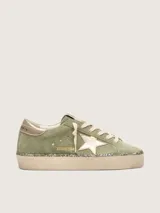Zapatillas Hi Star de Golden Goose con empeine de gamuza verde militar, estrella lateral y contrafuerte en cuero metalizado dorado, plataforma alta con canto revestido en glitter y cordones de algodón crudo.