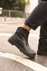 Bota de caña baja confeccionada en cuero vacuno encerado, con acabado texturizado y suela de goma cosida con plataforma.
