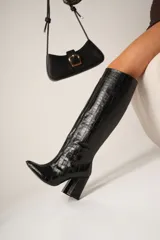 Botas altas de cuero vegano con estampado de cocodrilo, taco cuadrado y punta fina. Disponibles en color negro y marrón. La caña mide 40cm y el taco 8cm.