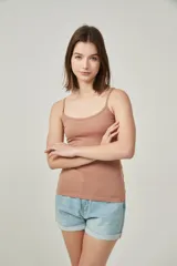 Musculosa de bretel fino color crudo, corte ajustado al cuerpo y escote redondo.