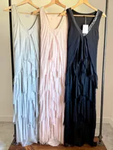 Vestido largo negro de seda con escote en V adornado con lentejuelas plateadas. Presenta un diseño de capas superpuestas con terminaciones deshilachadas que aportan volumen y movimiento. Es de corte sin mangas con breteles anchos y espalda elastizada.