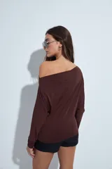 Top de manga larga con escote bote amplio, diseñado para usar ligeramente caído sobre los hombros. Presenta una silueta entallada y tejido liso, liviano y adaptable al cuerpo.