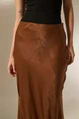 Falda midi evasé de poliéster color negro con textura sutil.