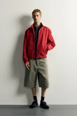 Cazadora relaxed fit de tejido ligero color azul marino, con cuello subido, manga larga y cierre frontal de cremallera. Cuenta con bolsillos frontales de vivo en la cadera y acabados en rib elástico en puños y cintura.
