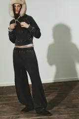 Pantalón de tiro medio con cintura elástica, confeccionado en mezcla de algodón con efecto lavado oscuro. Presenta un corte ancho y voluminoso, con paneles curvos cosidos en los laterales de las piernas.