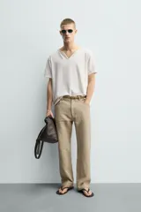 Camiseta de corte relajado con cuello redondo amplio tipo panadero, con detalle de botones y acabado irregular. Manga corta.