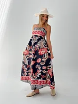 Vestido largo de algodón italiano con estampado floral en tonos azul, amarillo y blanco. Tiene escote cuadrado, corte imperio y elástico en la espalda.