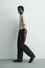 Jeans baggy fit de corte holgado en color negro con efecto lavado, confeccionados en denim de algodón rígido, con diseño clásico de cinco bolsillos y cierre frontal con cremallera y botón.