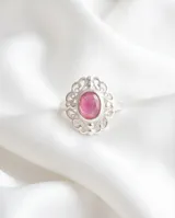 Anillo de plata 925 con piedra central ovalada de raíz de rubí en tono rosado, rodeada por un diseño de filigrana ornamentado.