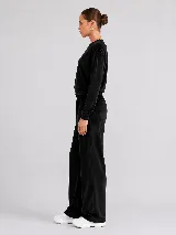 Pantalón de corte recto confeccionado en tejido plush con acabado aterciopelado. Presenta cintura elástica, bolsillos laterales y un bolsillo trasero, ofreciendo una caída fluida y cómoda.