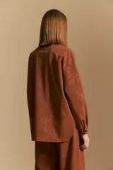 Sobrecamisa de efecto engomado en color negro, con textura lavada, cuello clásico, cierre frontal con botones a tono y bolsillos frontales con solapa.
