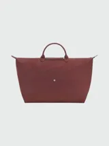 Bolso de mano tipo tote de la línea Le Pliage One de Longchamp, en color bordó. Presenta un diseño minimalista con cierre de cremallera superior, solapa con botón a presión y asas cortas de cuero.