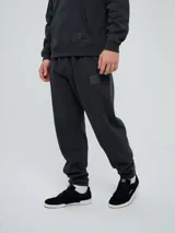 Pantalón jogger Umbro de felpa en color gris oscuro, con cintura elástica con cordón ajustable, puños elásticos en los tobillos, costuras frontales en las piernas y etiqueta con el logo de la marca en la parte delantera.