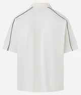 Remera tipo polo de hombre, color blanco crudo, con escote en V ribeteado en negro y ribetes negros en las costuras de los hombros. Presenta la inscripción arqueada "NEW YORK" en negro en el pecho.