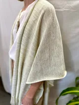 Ruana tejida de textura suave y liviana, color dorado, con flecos en los extremos.