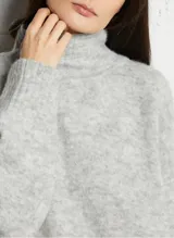 Sweater de punto de corte amplio y holgado, con cuello alto y mangas largas. Confeccionado en una mezcla de lana y alpaca, presenta una textura mullida y compacta.