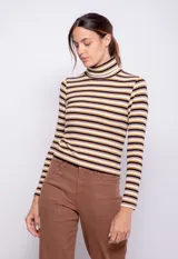 Polera de manga larga con cuello alto, confeccionada en tejido de punto con diseño de rayas horizontales en blanco y negro.