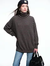 Polera de tejido de punto con diseño de rayas horizontales en color negro y marrón. Presenta cuello alto, hombros caídos y un corte relajado y holgado.