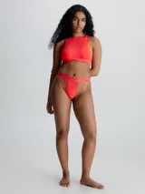 Corpiño deportivo rojo Calvin Klein Deconstructed, con cuello redondo y detalle cut-out en los hombros. Presenta copas suaves sin relleno y banda inferior elástica con logo de la marca.