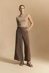 Top sin mangas de tejido texturizado con brillo integrado, color beige dorado, con cuello alto y hombros levemente estructurados.