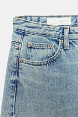 Jeans de tiro medio con diseño wide leg y pernera ancha, estilo de cinco bolsillos, cierre frontal con cremallera y botón metálico.