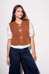 Chaleco marrón de punto con botones dorados y bolsillos delanteros.