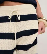 Pantalón de punto a rayas horizontales anchas, color blanco y azul marino, de corte recto y tiro alto con cintura elástica y lazo ajustable.