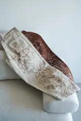 Pantalón slouchy color beige de gabardina de algodón con bordado floral marrón.