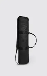 Bolso cilíndrico porta yoga-mat color negro, confeccionado en cordura de alta densidad. Cuenta con correas regulables grabadas con el logo de la marca, manijas cortas para agarre manual, compartimento principal con cierre metálico reforzado y un bolsillo trasero pequeño con cierre para objetos de valor.