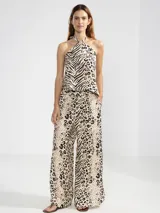 Pantalón de lino italiano con estampa combinada de animal print tipo leopardo y cebra en tonos crema y negro. Presenta corte recto, talle medio y bolsillos delanteros.
