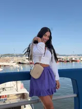 Bandolera de símil cuero color verde oliva, con diseño de dos compartimentos con cierre y correa ajustable de tela con patrón geométrico.