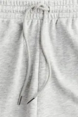 Short de felpa liviana de mezcla de algodón, color gris melange. Modelo con elástico revestido en la cintura y cordón ajustable. Presenta bolsillos discretos en las costuras laterales y ruedo redondeado.