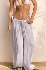 Pantalón de tiro medio, color negro, confeccionado en tejido satinado con diseño de pierna ancha y cintura elástica ajustable con cordón.
