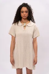 Vestido corto color crema, tejido a crochet con cuello polo y mangas cortas.